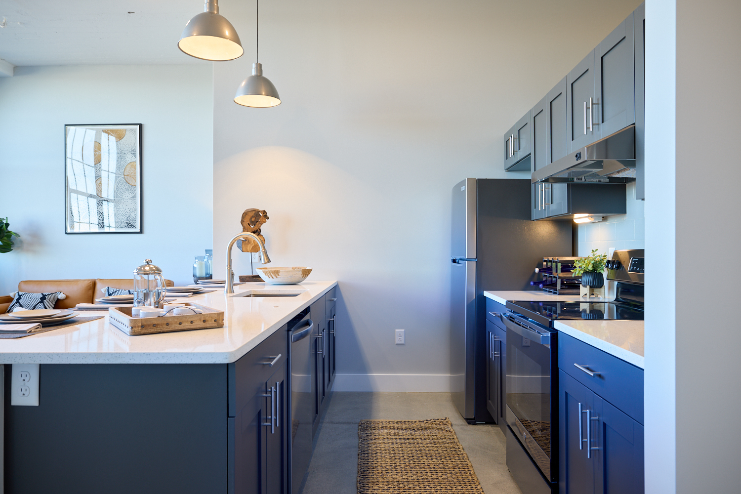 A photo of an open-concept kitchen with white countertops and blue cabinets.