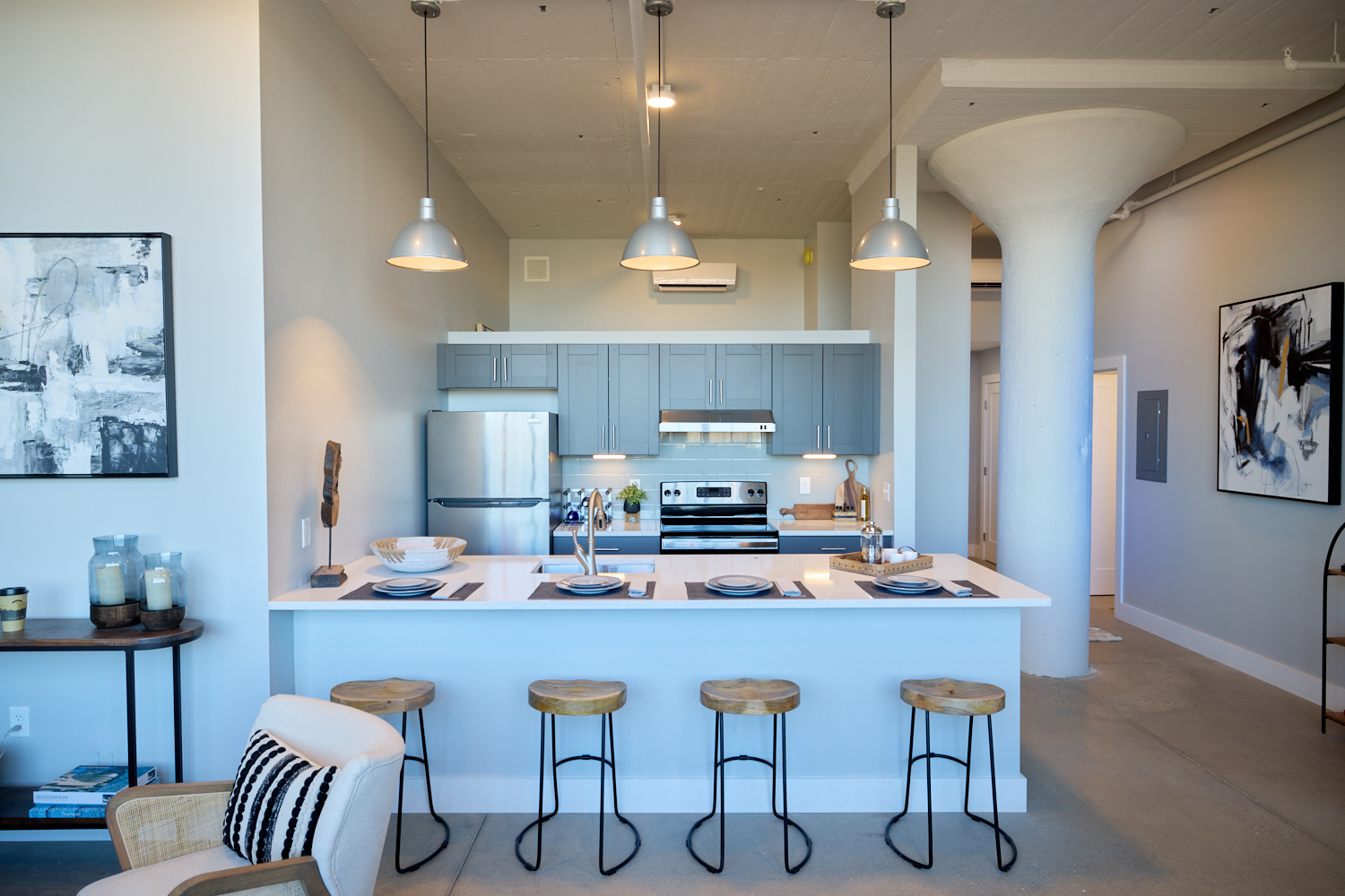 A white open-concept kitchen with four places set at the breakfast bar.