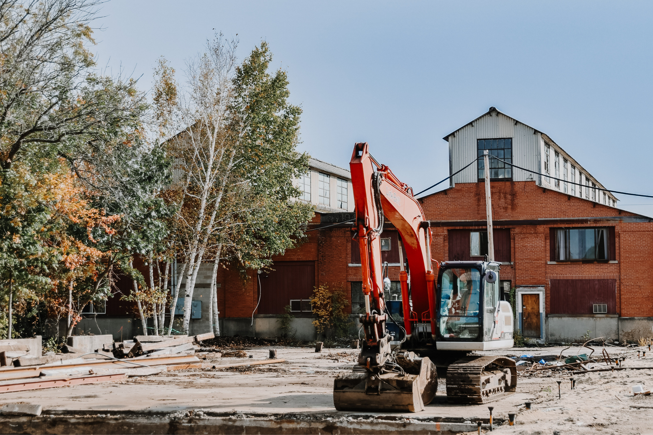 Photo of a group of three men sitting around a table discussing building plans.